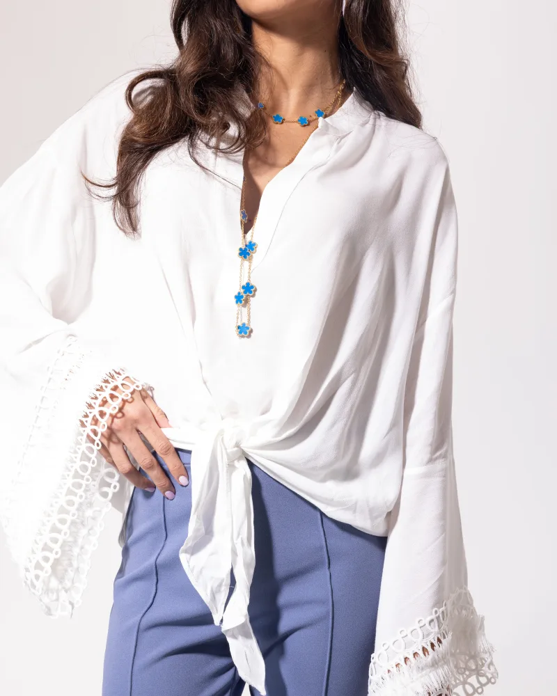 Blouse blanche Licorne Passion détail buste, col tunisien boutonné et manches évasées en dentelle ajourée