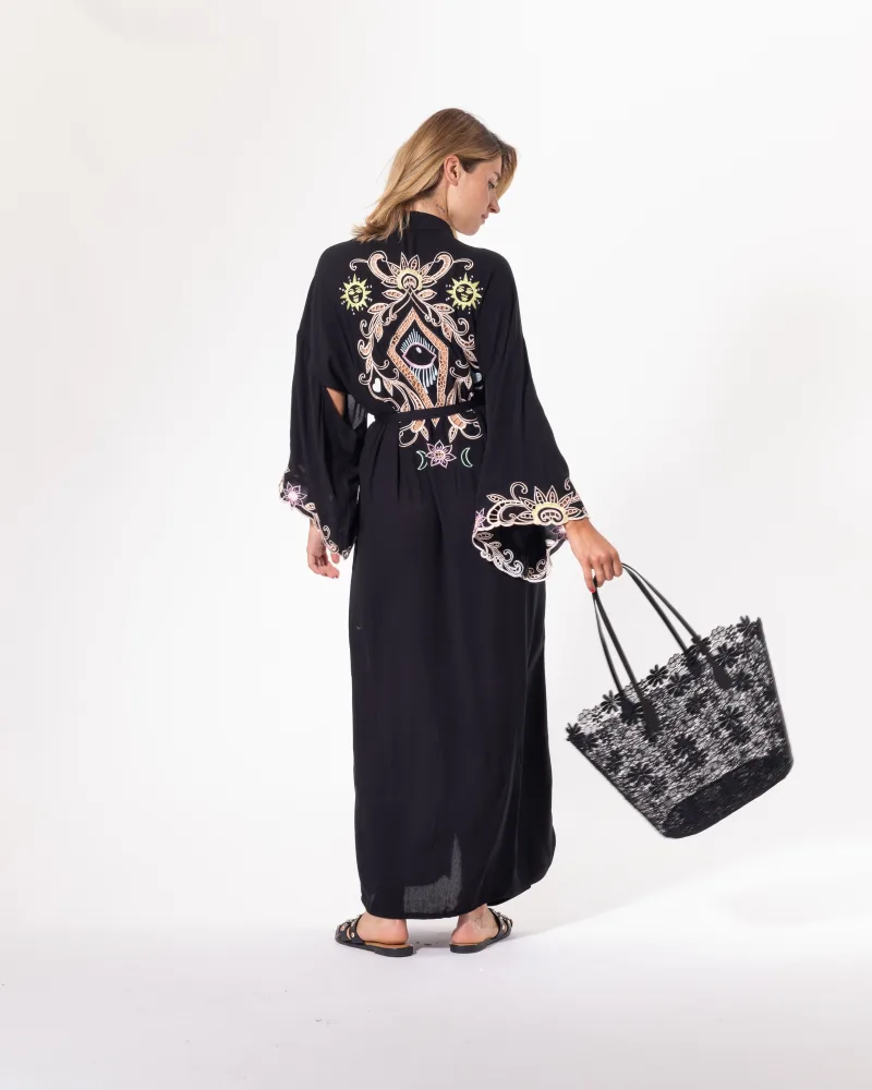 Kimono long noir Licorne Passion porté avec sac à main, broderies bohèmes et manches évasées