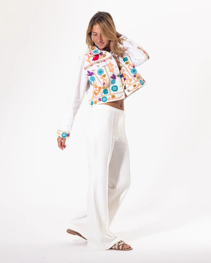 Blouson brodé blanc Licorne Passion porté avec pantalon large blanc, broderies multicolores florales