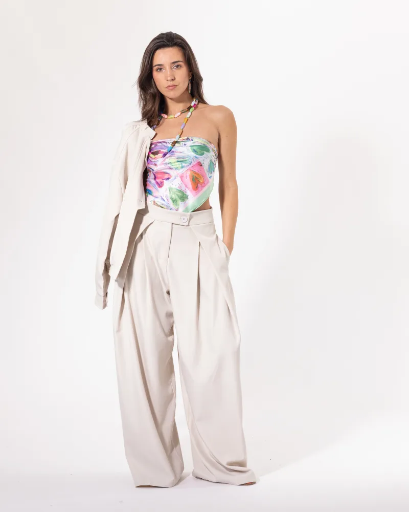 Pantalon large beige Licorne Passion porté avec un top fleuri, coupe wide leg à plis marqués et taille haute