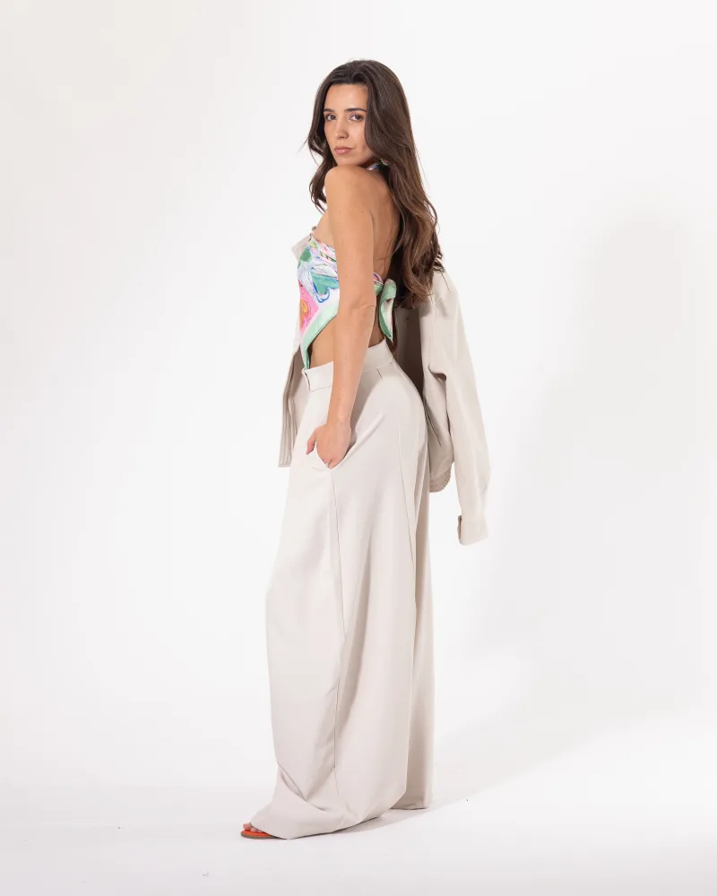 Pantalon large beige Licorne Passion vu de côté, coupe wide leg fluide et taille haute à plis marqués