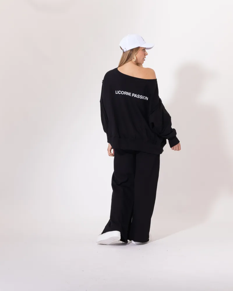 Ensemble jogging noir Licorne Passion vu de dos, sweat oversize épaule dénudée et pantalon ample
